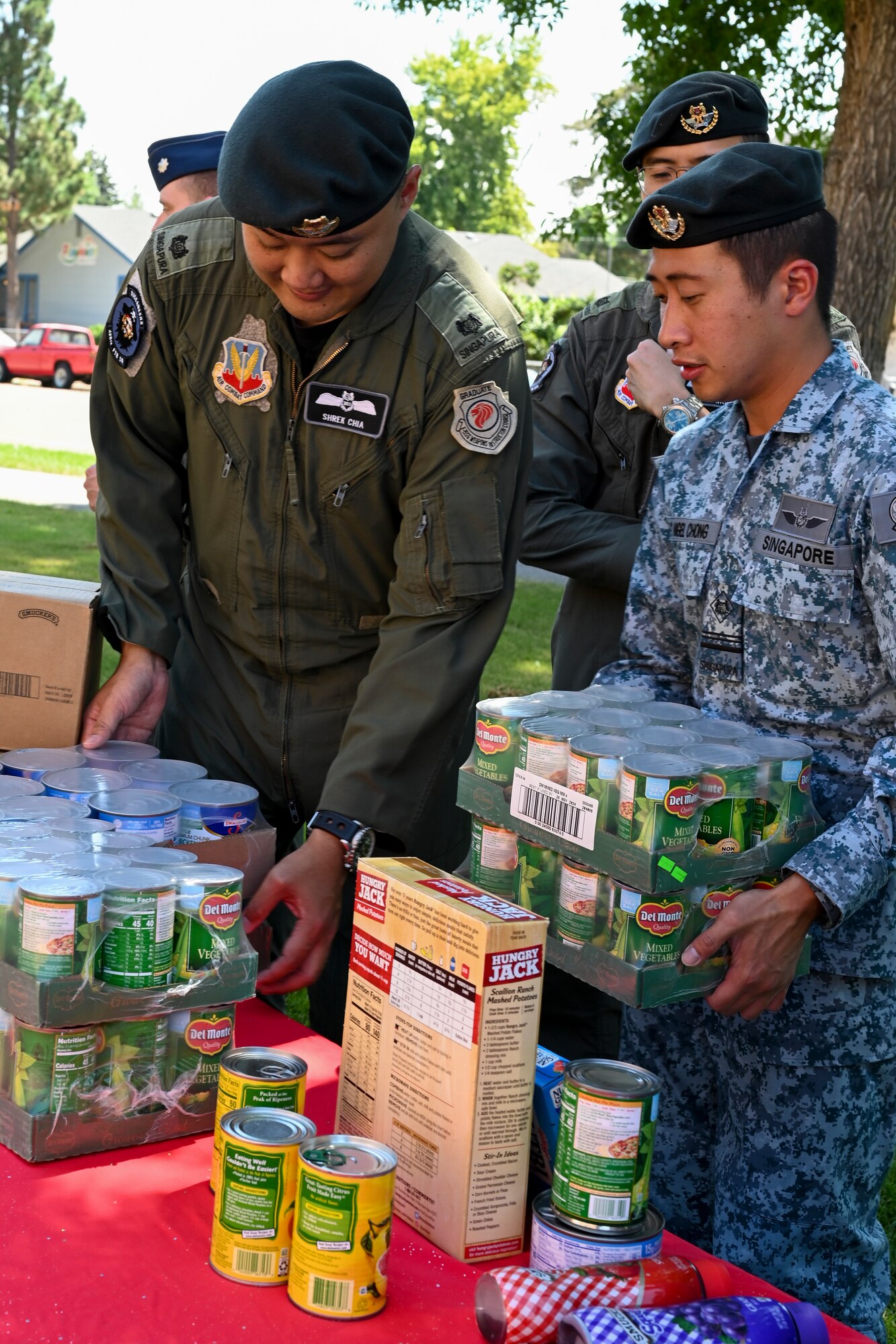 Republic of Singapore Air Force Maj. Chia Chi Yu and Military Expert 5-2 Nigel Chong, 428th Fighter Squadron from the Republic of Singapore Air Force, pick up food donations.