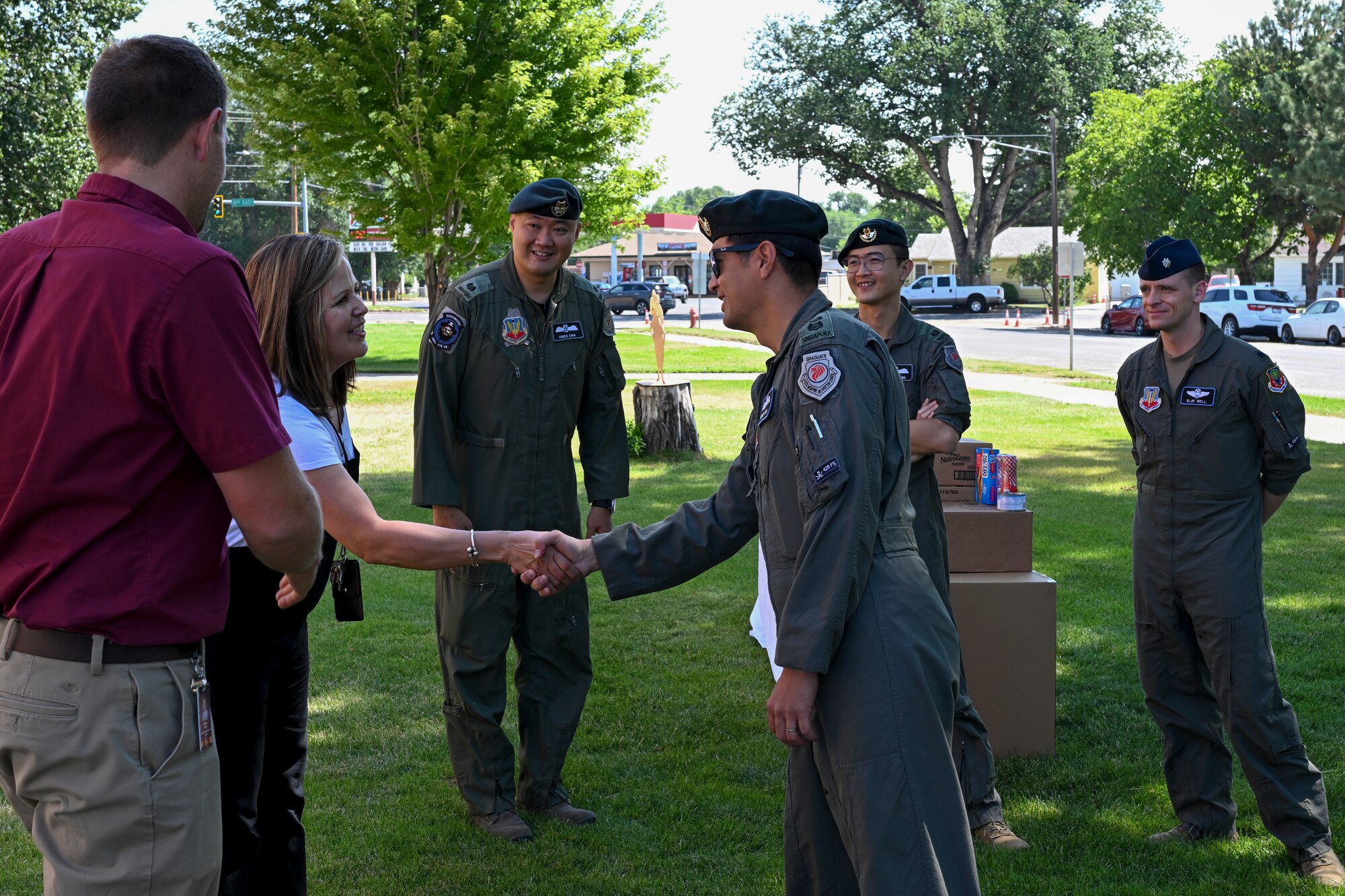 Republic of Singapore Air Force Lt. Col. Shewan Goh shakes hands with the principal and a counselor of Bennett Mountain High School.