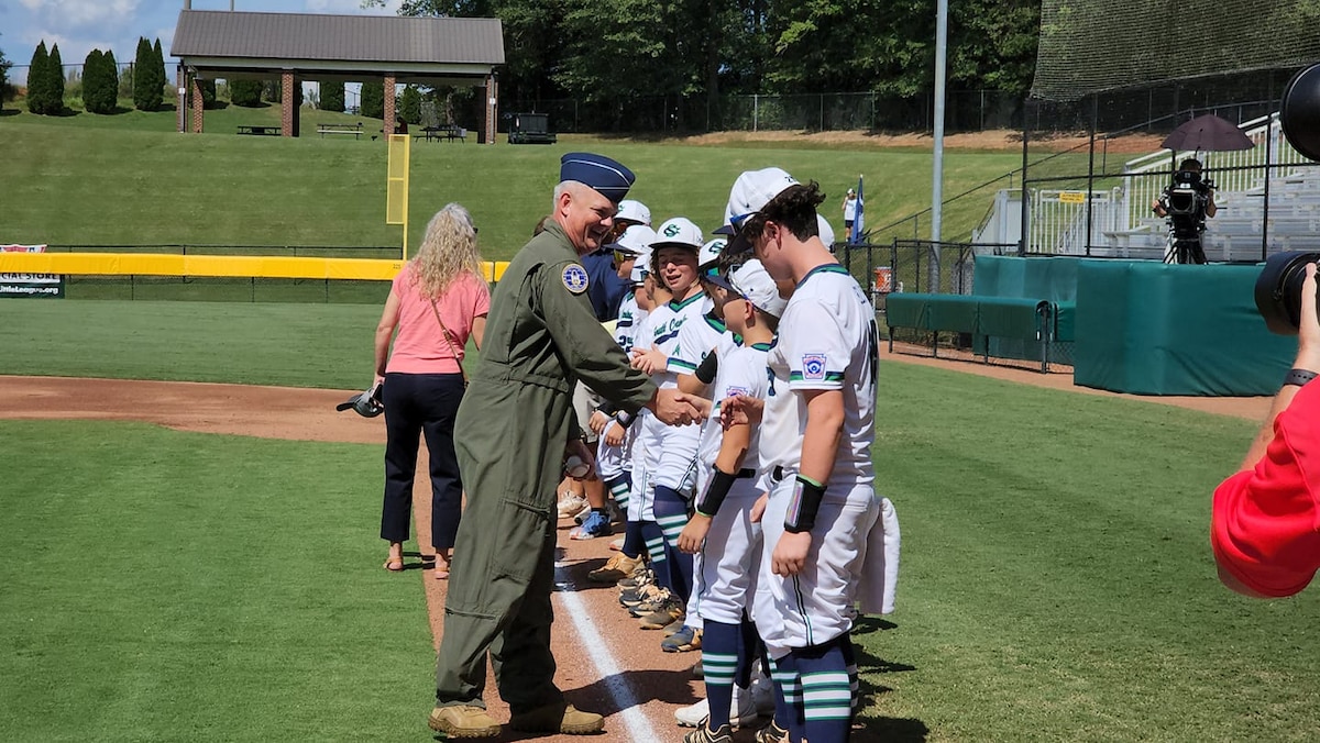 Brig. Gen. Scott Durham, AFRC Director of Air, Space, and Information Operations, shakes hands with a team before a Southeast Region Little League Baseball Tournament game August 5, 2022, in Warner Robins, Georgia.