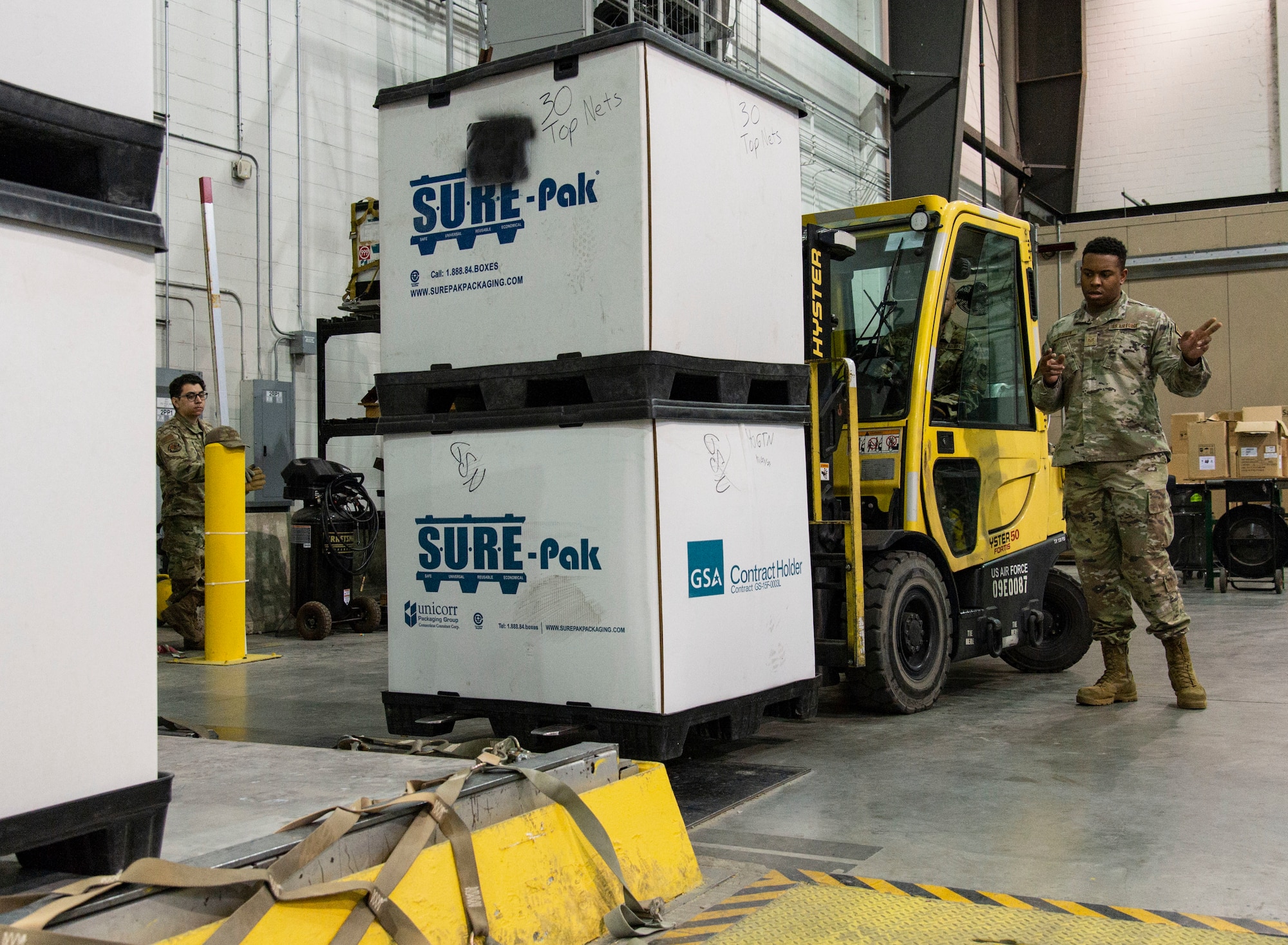 Staff Sgt. Derieo Herron, 436th Maintenance Squadron aircraft structural maintenance craftsman, marshals Senior Airman Akeem Moffatt, 436th Aerial Port Squadron cargo processor, into alignment with a pallet at Dover Air Force Base, Delaware, March 31, 2022. Students participating in a multi-capable Airmen training class received basic pallet building instructions and were assisted by 436th Aerial Port Squadron personnel. (U.S. Air Force photo by Roland Balik)