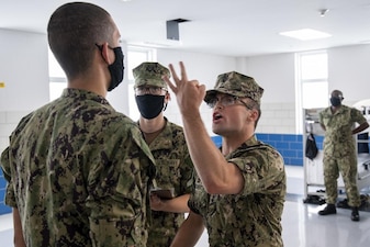 220711-N-ZW825-0301 GREAT LAKES, Ill. (July 11, 2022) A Naval Reserve Officers Training Corps (NROTC) New Student Indoctrination (NSI) instructor asks a midshipman candidate his third general order during a working uniform inspection at Recruit Training Command (RTC), July 11. Upon completion of NSI, the candidates will start their freshman year of the NROTC program at colleges and universities nationwide this fall. NSI is an indoctrination program hosted at RTC, and provides midshipmen with a common military training orientation. NSI provides basic training in five warfighting fundamentals – firefighting, damage control, seamanship, watchstanding and small arms handling and marksmanship – to begin creating basically trained and smartly disciplined future Navy and Marine Corps officers. NROTC is overseen by Commander, Naval Service Training Command (NSTC), Rear Adm. Jennifer S. Couture, which supports naval accessions training for 98 percent of the Navy’s new officers and enlisted Sailors. (U.S. Navy photo by Chief Mass Communication Specialist Byron C. Linder)