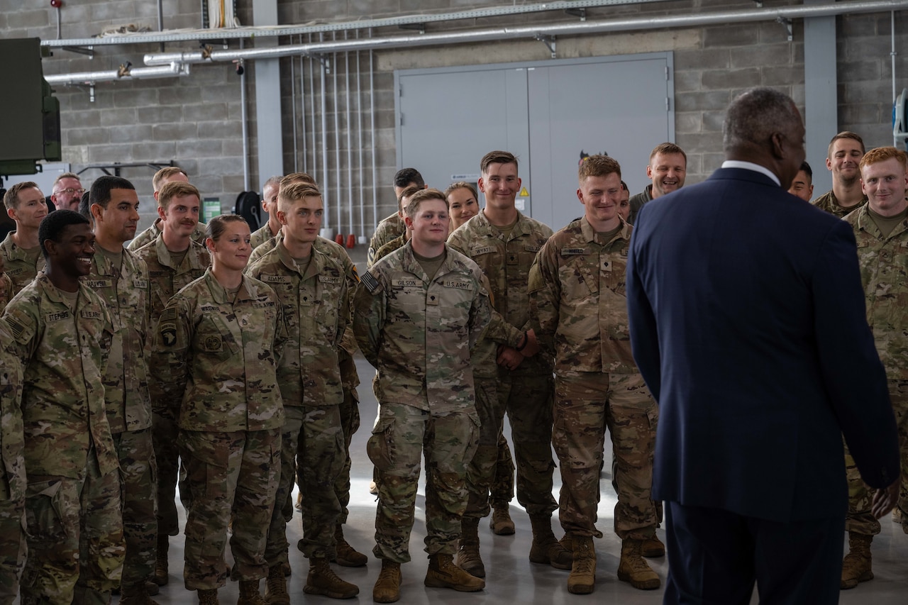 A man talks to a group of soldiers.