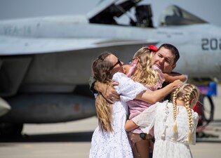 Cmdr. Marvin Wynn, executive officer of the "Tophatters" of Strike Fighter Squadron (VFA) 14, greets his family during a homecoming celebration at Naval Air Station Lemoore, Calif.