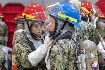 220715-N-ZW825-0434 GREAT LAKES, Ill. (July 15, 2022) Naval Reserve Officers Training Corps (NRTOC) New Student Indoctrination (NSI) midshipman candidates assist each other with donning the self-contained breathing apparatus during firefighting application training at Recruit Training Command (RTC), July 15. Upon completion of NSI, the candidates will start their freshman year of the NROTC program at colleges and universities nationwide this fall. NSI is an indoctrination program hosted at RTC, and provides midshipmen with a common military training orientation. NSI provides basic training in five warfighting fundamentals – firefighting, damage control, seamanship, watchstanding and small arms handling and marksmanship – to begin creating basically trained and smartly disciplined future Navy and Marine Corps officers. NROTC is overseen by Commander, Naval Service Training Command (NSTC), Rear Adm. Jennifer S. Couture, which supports naval accessions training for 98 percent of the Navy’s new officers and enlisted Sailors. (U.S. Navy photo by Chief Mass Communication Specialist Byron C. Linder)