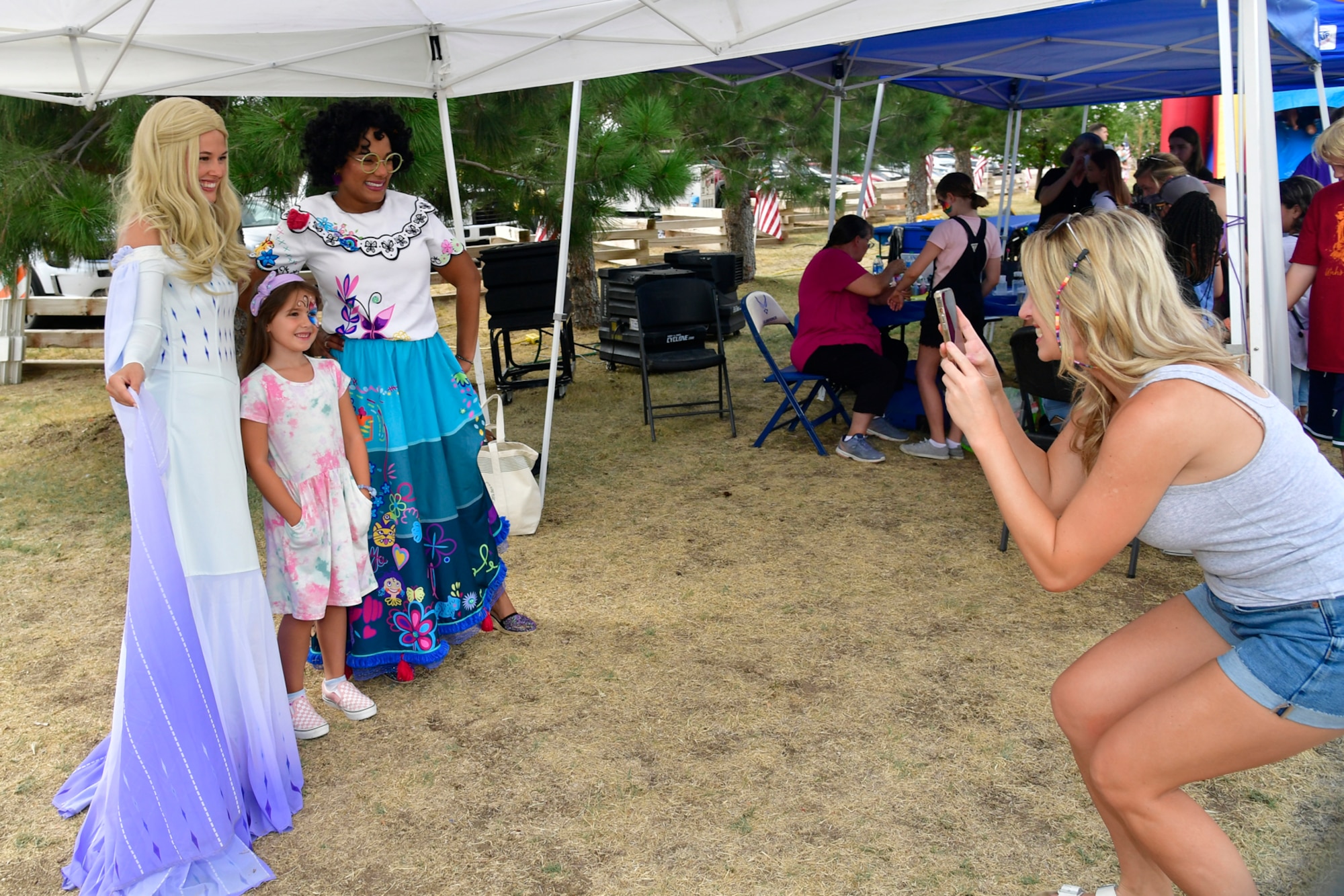 Cloe Taylor poses for a picture with Elsia and Marbella, played by Brooke Ballard and Veonka White, during the Military Salute Picnic held at Centennial Park Aug. 5, 2022, at Hill Air Force Base, Utah. The annual event is sponsored by the Top of Utah Military Affairs Committee and provided fun activities, free food and live entertainment for the base’s military and their families. (U.S. Air Force photo by Todd Cromar)