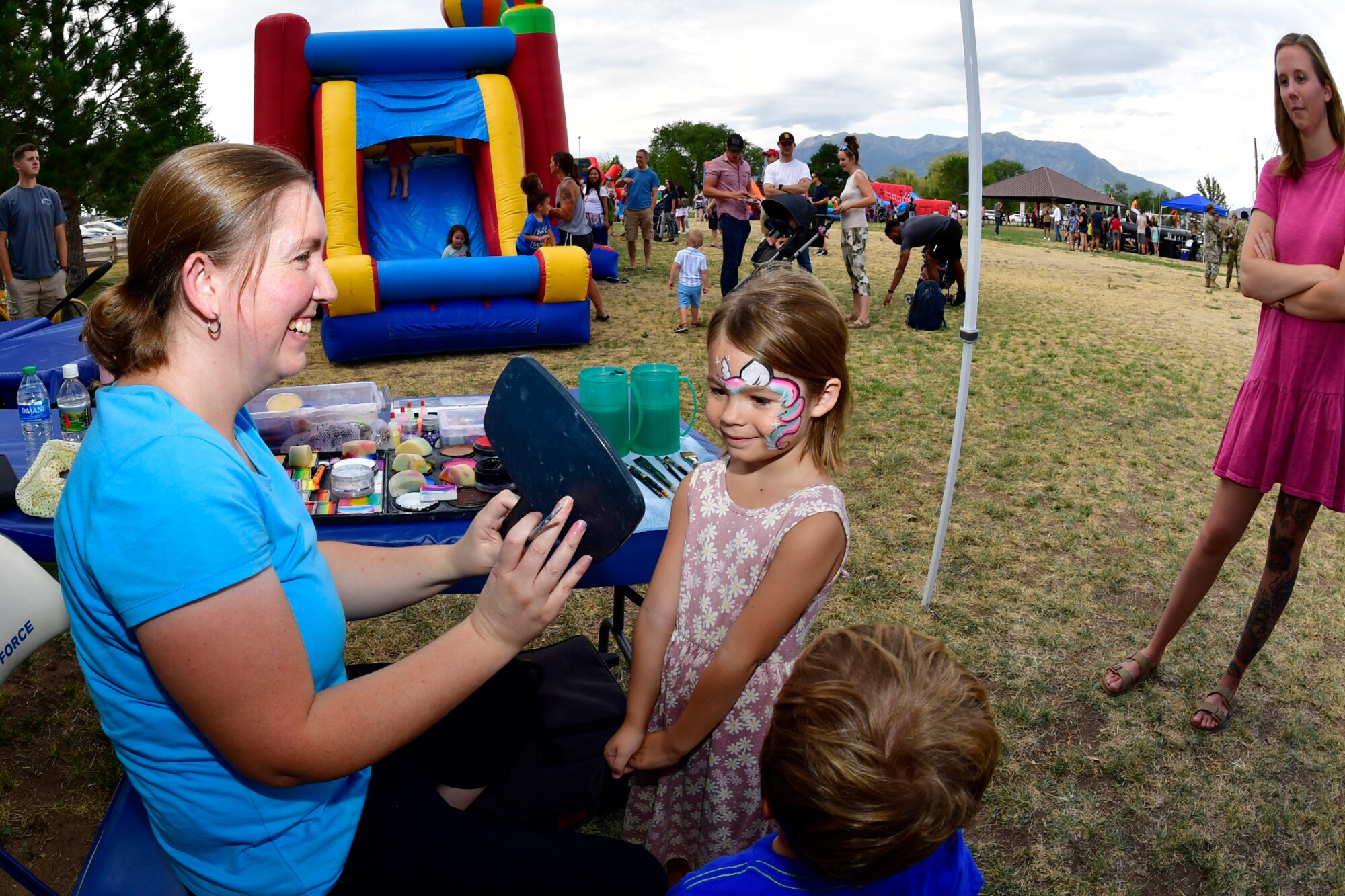 Lylia Shorts views her painted face in a hand mirror held by Cindy Phills, Changing Faces, during the Military Salute Picnic held at Centennial Park Aug. 5, 2022, at Hill Air Force Base, Utah. The annual event is sponsored by the Top of Utah Military Affairs Committee and provided fun activities, free food and live entertainment for the base’s military and their families. (U.S. Air Force photo by Todd Cromar)