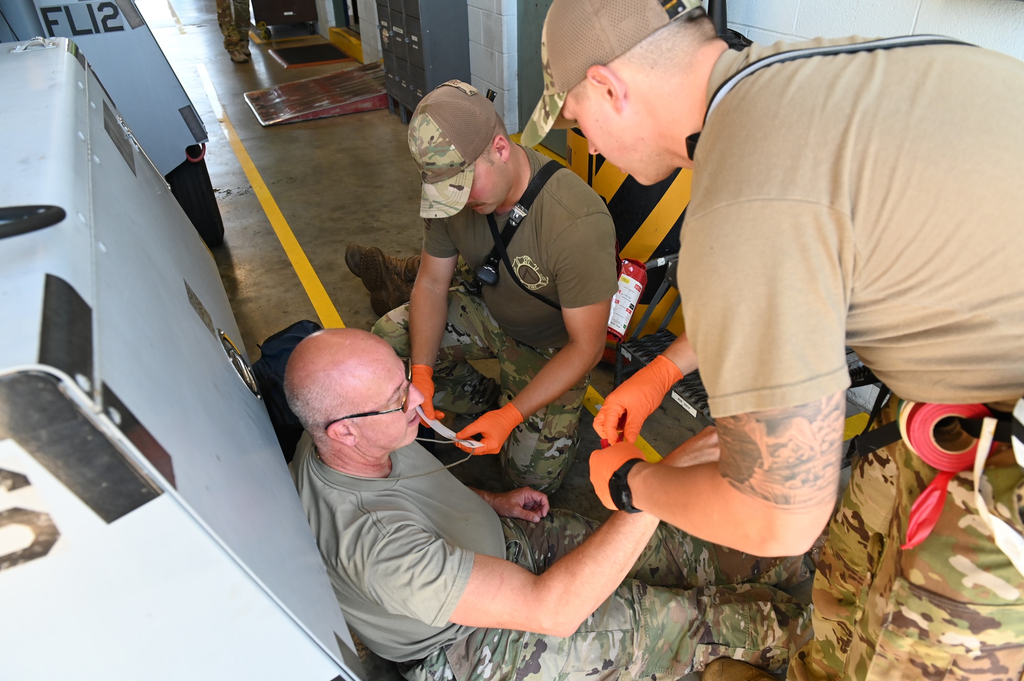 167th Airlift Wing firefighters, Senior Airman Levi Taylor and Senior Airman Eric Myers, treat a simulated victim during an active shooter training event at Shepherd Field, Martinsburg, West Virginia, Aug 7, 2022.