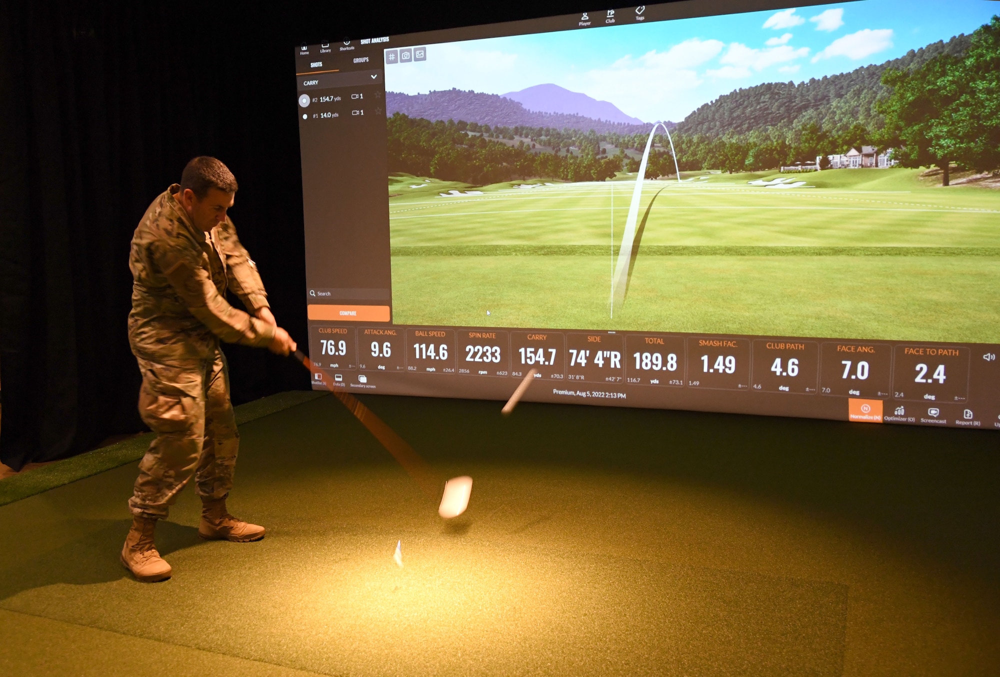 U.S. Air Force Col. Jason Allen, 81st Training Wing vice commander, takes a swing during the Indoor Golf Simulator ribbon cutting ceremony outside the Bay Breeze Event Center at Keesler Air Force Base, Mississippi, Aug. 5, 2022. The simulator has the latest golf shot tracking technology and allows the virtual play on over 250 famous golf courses worldwide. (U.S. Air Force photo by Kemberly Groue)