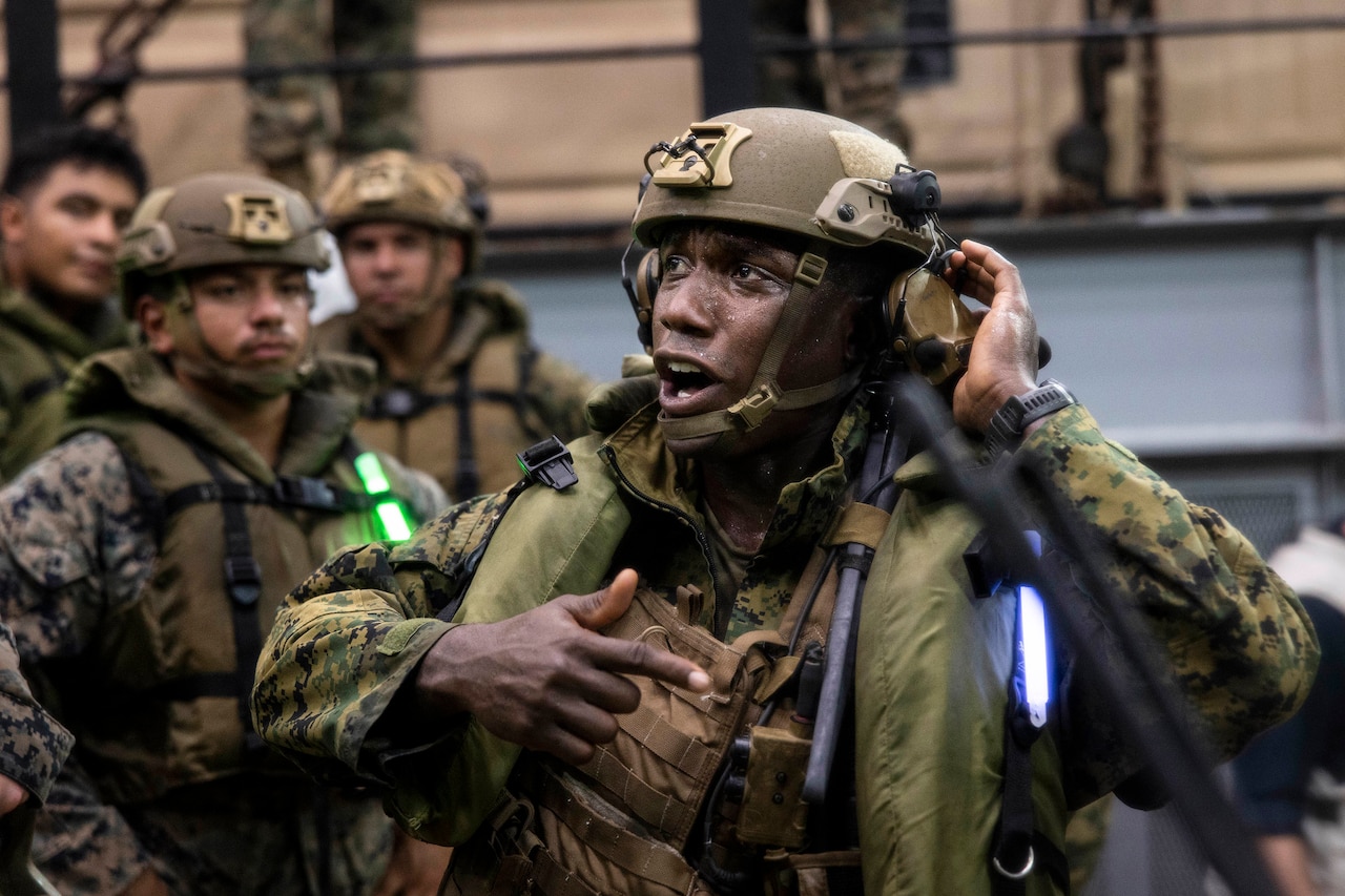 A Marine speaks to fellow troops.