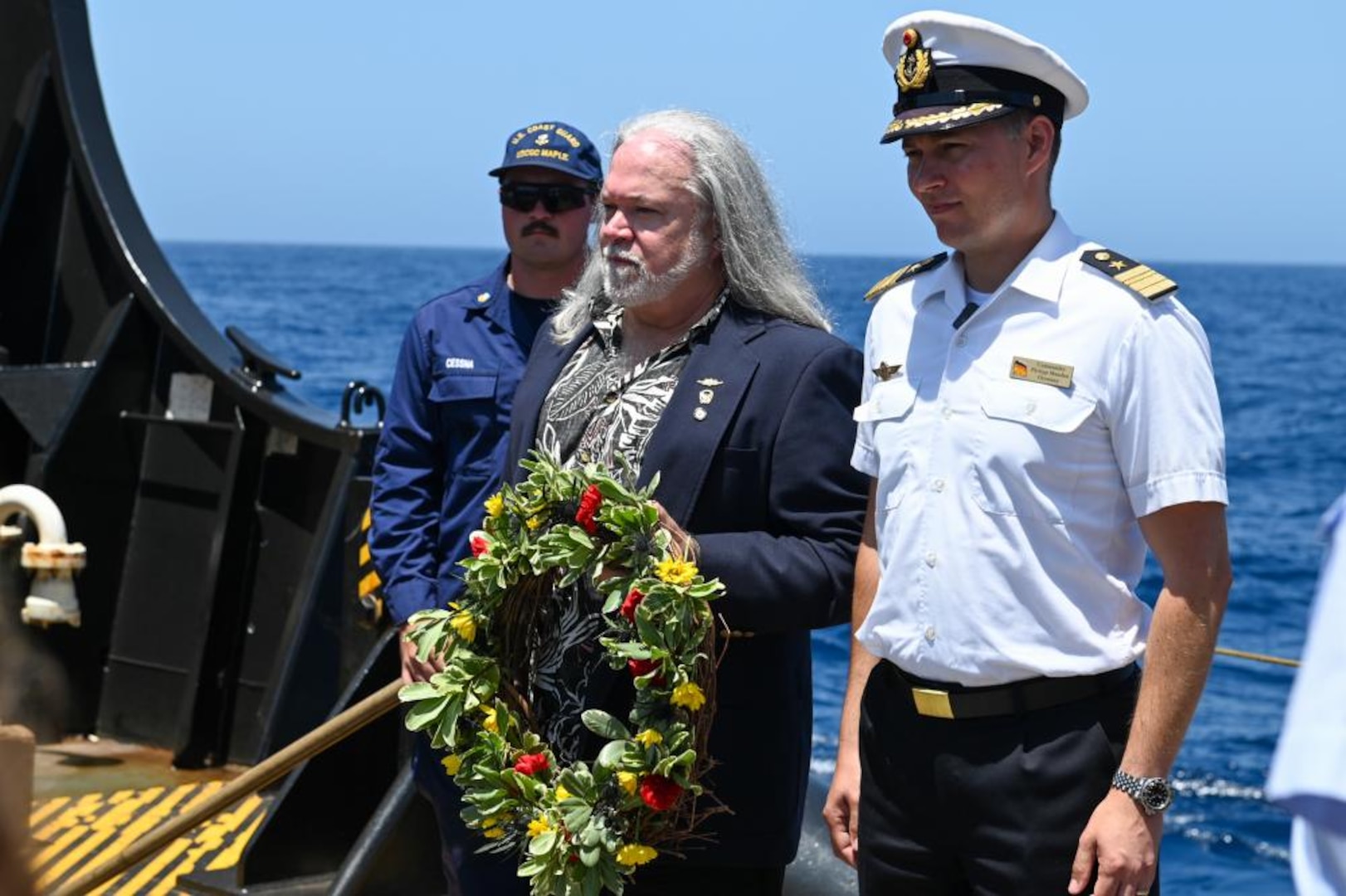 Commander Philipp Mandau, the Assistant Naval Attaché to the United States for the Federal Republic of Germany, and Gary Thomas, retired Coast Guard Commander, lay a wreath at the sight of a sunken German U-boat on the Maple buoy deck at the Graveyard of the Atlantic, June 13, 2022. The crew of the Maple commemorated lives lost by visiting two sunken Coast Guard Cutters and a German U-boat. (U.S. Coast Guard photo by Petty Officer 3rd Class Kimberly Reaves)