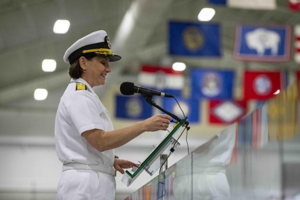 GREAT LAKES, Ill. (Aug. 8, 2022) Commander, Naval Service Training Command (NSTC), Rear Adm. Jennifer S. Couture, speaks during the graduation ceremony for Naval Reserve Officers Training Corps (NROTC) New Student Indoctrination (NSI) Cycle 3 midshipman candidates inside the Midway Ceremonial Drill Hall at Recruit Training Command (RTC), August 8. The midshipmen will start their freshman year of the NROTC program at colleges and universities nationwide this fall. NSI is an indoctrination program hosted at RTC, and provides midshipmen with a common military training orientation. NSI provides basic training in five warfighting fundamentals – firefighting, damage control, seamanship, watchstanding and small arms handling and marksmanship – to begin creating basically trained and smartly disciplined future Navy and Marine Corps officers. NROTC is overseen by NSTC, which supports naval accessions training for 98 percent of the Navy’s new officers and enlisted Sailors. (U.S. Navy photo by Mass Communication Specialist 2nd Class Nikita Custer)