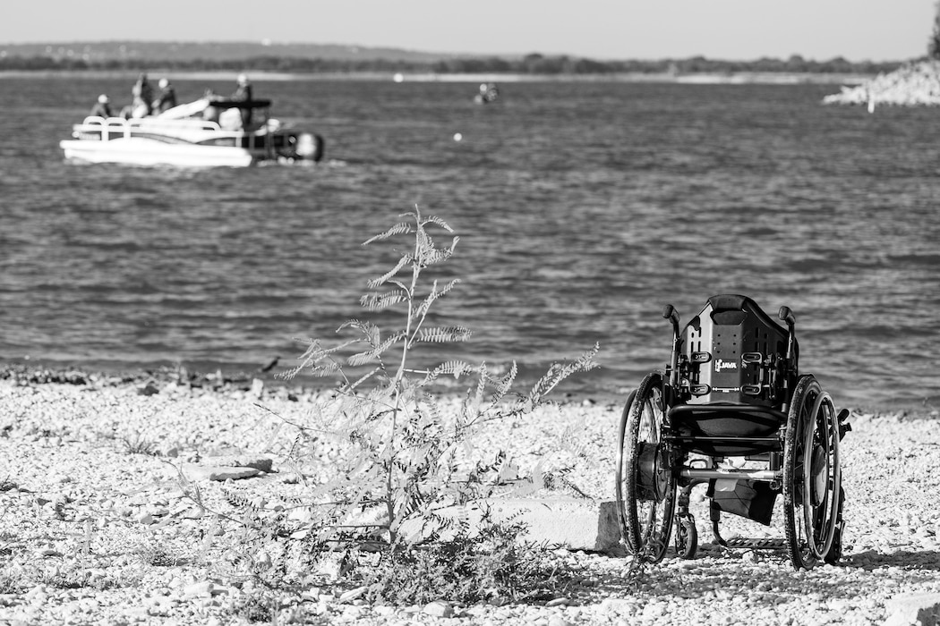 a wheelchair on the shoreline of a lake