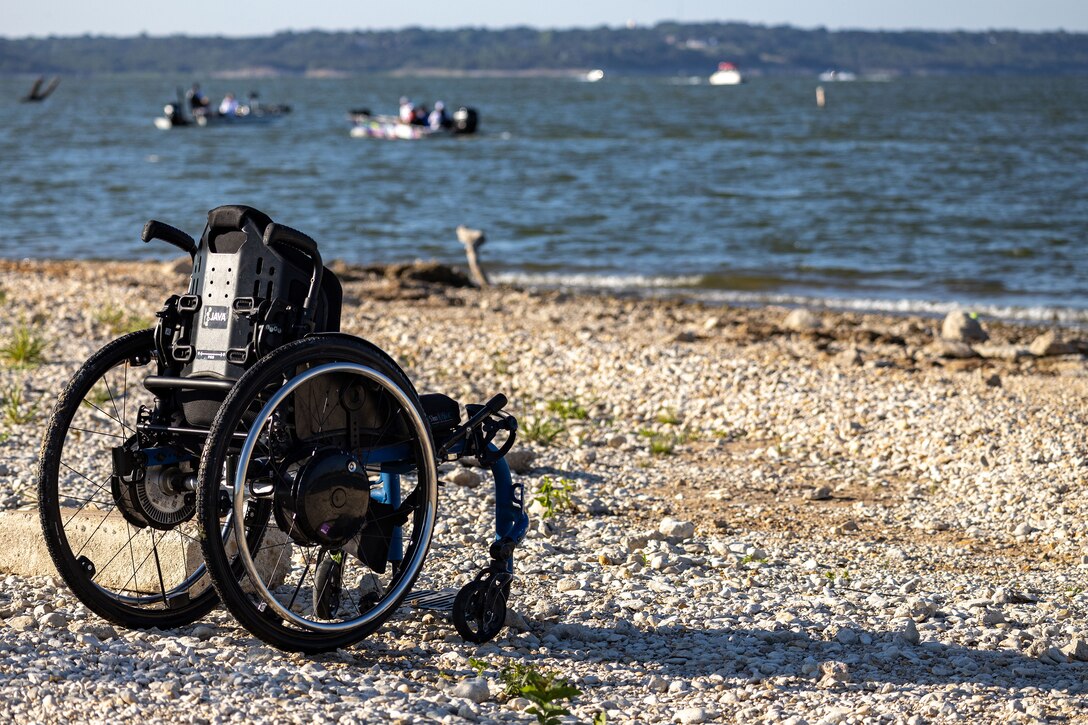 a wheelchair on the shoreline of a lake