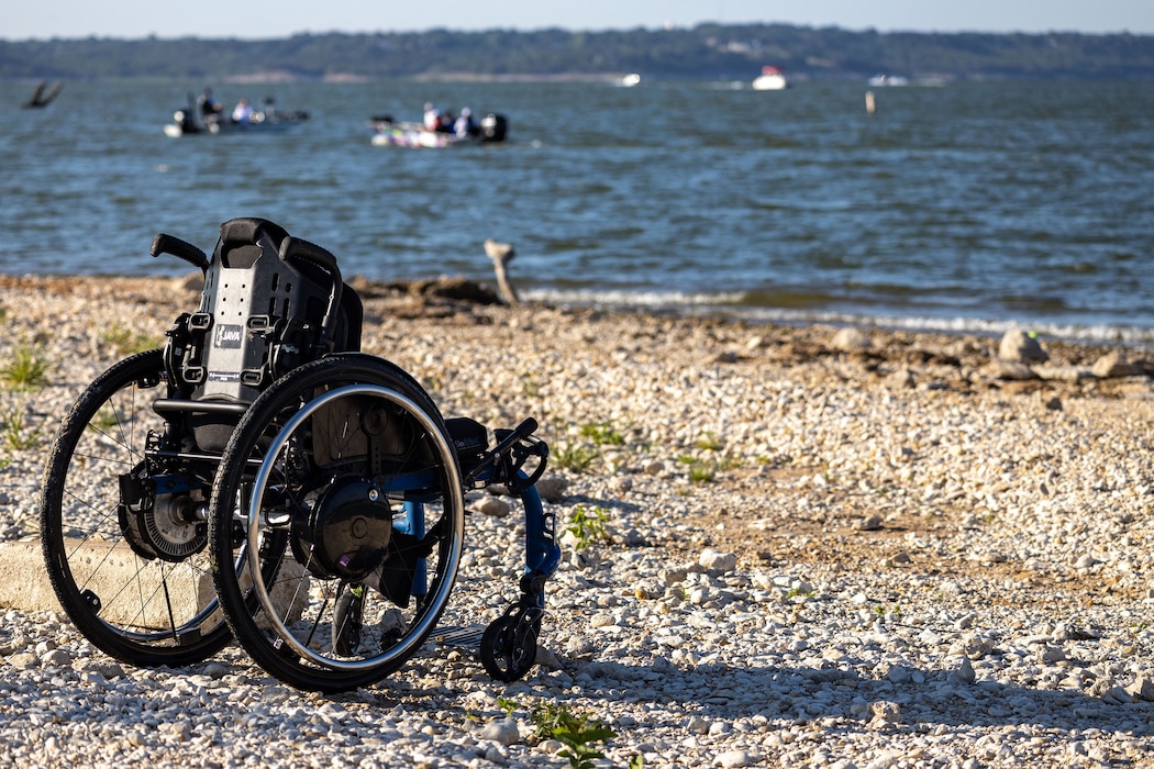 a wheelchair on the shoreline of a lake