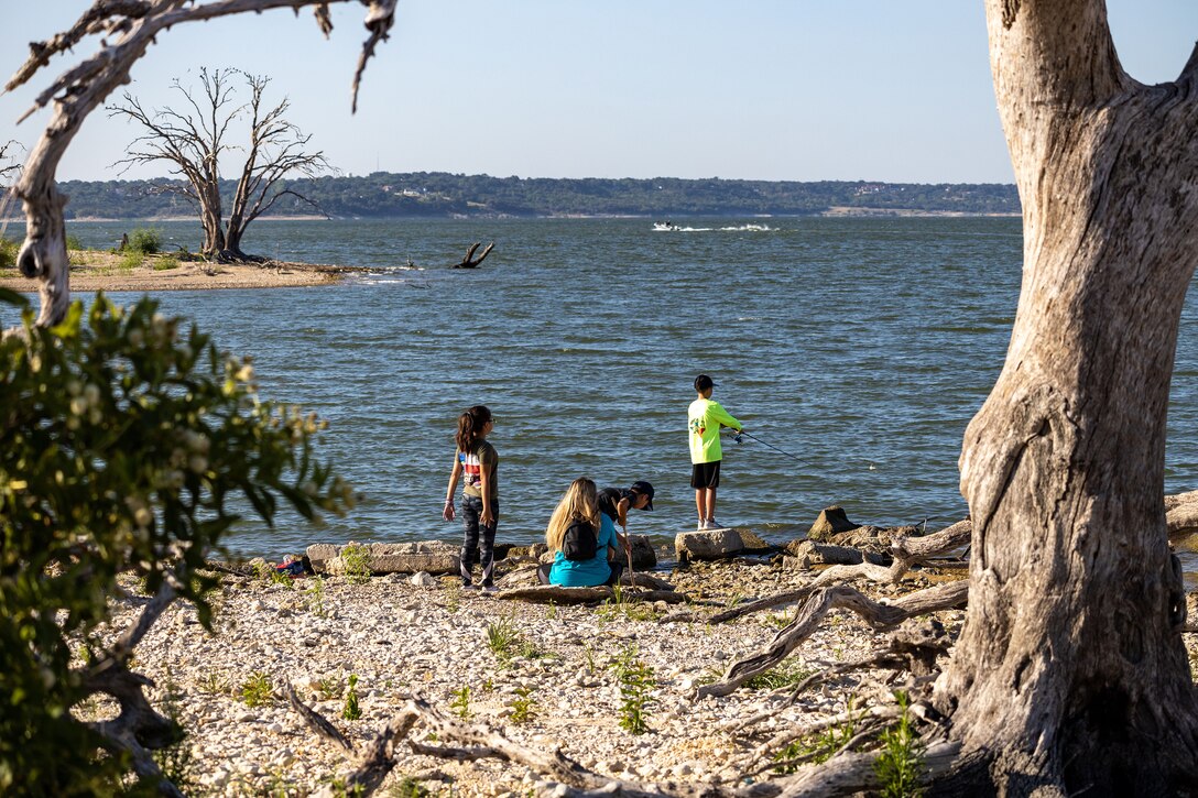 people fishing from a lake shore