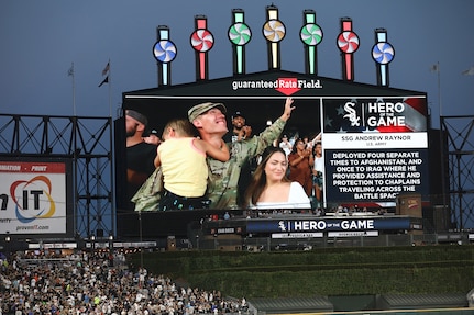 U.S. Army Reserve Staff Sgt. Andrew Raynor, with his son, Jacob, and wife Stacy, are cheered on a jumbotron during a ‘Hero of the Game’ honor at a Chicago White Sox versus Kansas City Royals game in Chicago, August 2, 2022.