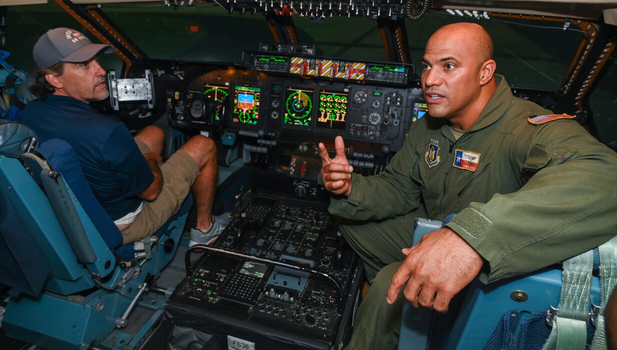 Lt. Col. Christopher Jones, 68th Airlift Squadron C-5M pilot, guides Brad Tobler, Wish for Our Heroes chapter director and co-owner of Federal Employee Benefits, inside the C-5M Super Galaxy flight simulator at Joint Base San Antonio-Lackland, Texas, Aug. 6, 2022. The flight simulator was part of an honorary commander tour of the 433rd Operations Group. (U.S. Air Force photo by Airman 1st Class Mark Colmenares)