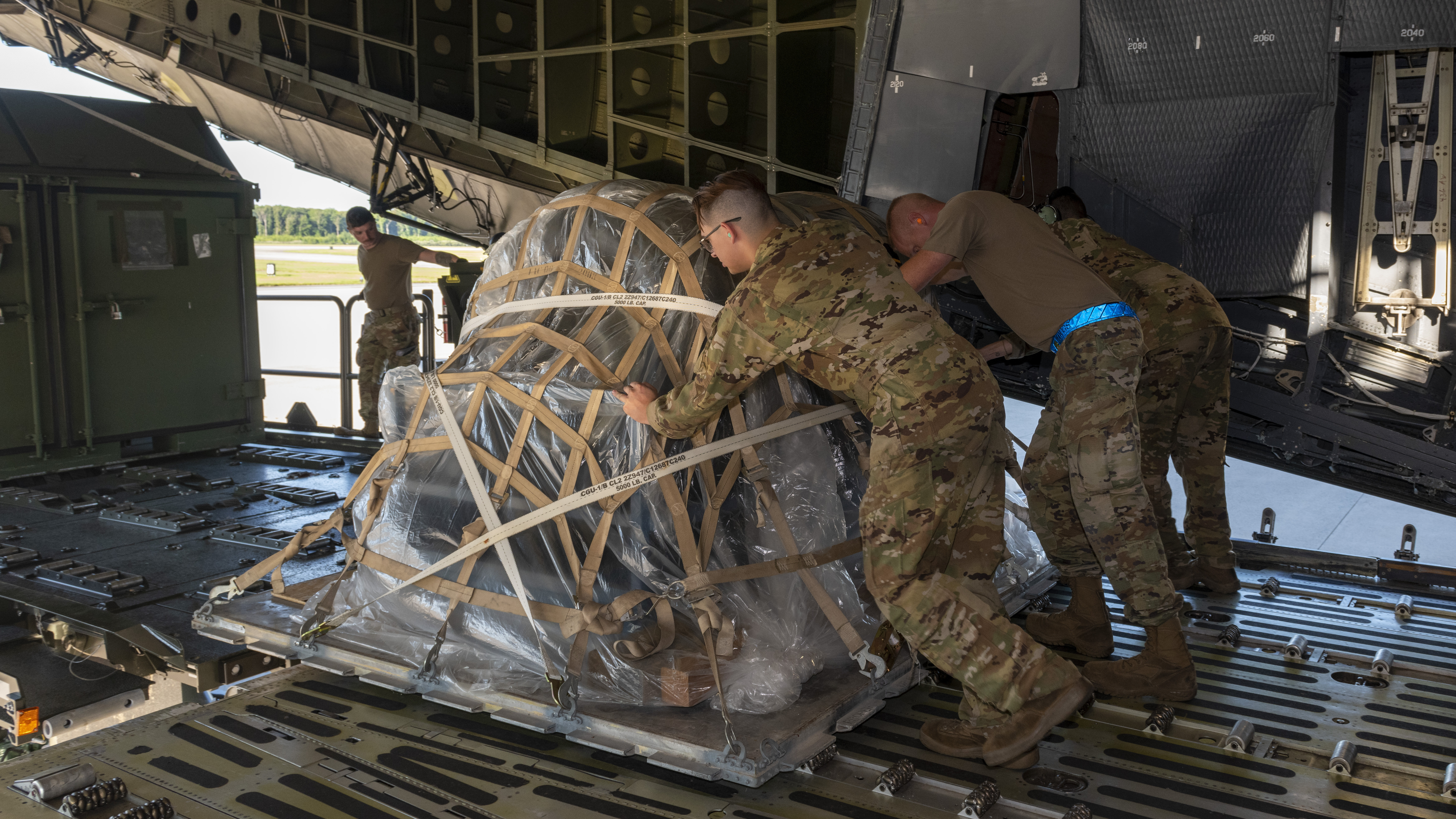 Members from the 9th Airlift Squadron and 436th Aerial Port Squadron push cargo onto a K-loader during the Liberty Eagle Readiness Exercise at Dover Air Force Base, Delaware, July 11, 2022. Members from both the 512th and 436th airlift wings participated in a simulated deployment to a forward operating base, located on Dover AFB, July 11-15, 2022. The purpose of this exercise was to validate the 512th and 436th airlift wings' ability to generate, employ and sustain airpower across the world in a contested and degraded operational environment. (U.S. Air Force photo by Senior Airman Shayna Hodge)