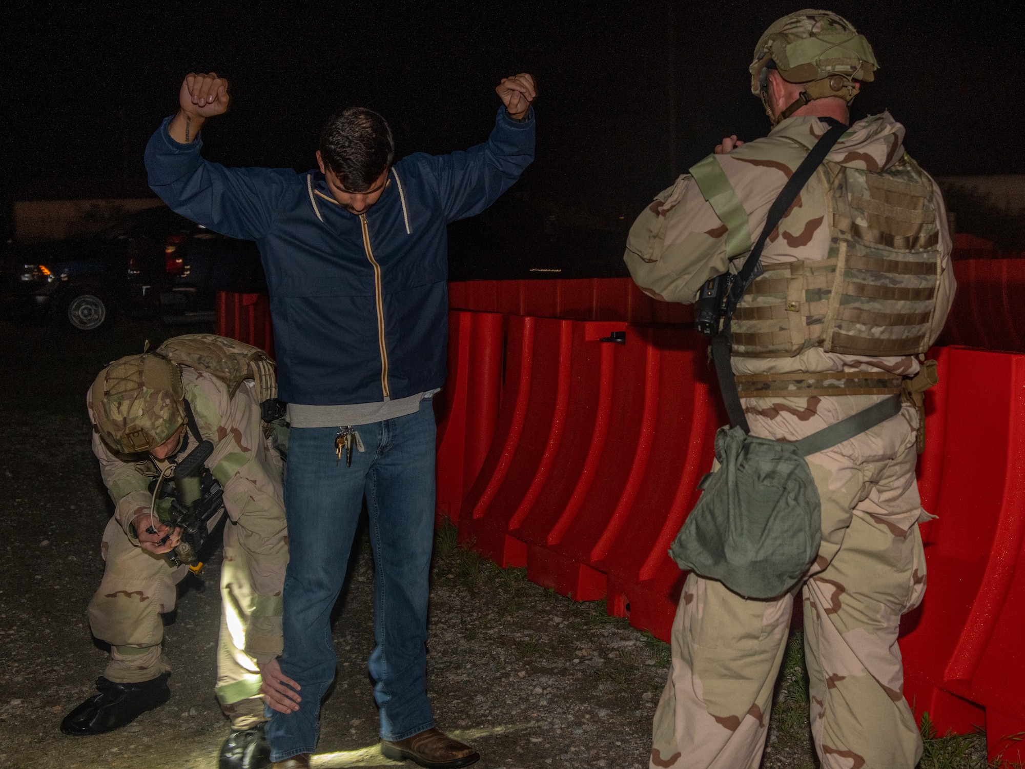 Members from the 512th and 436th security forces squadrons inspect a simulated defector at an entry control point during the Liberty Eagle Readiness Exercise at Dover Air Force Base, Delaware, July 13, 2022. Both squadrons simulated guarding an ECP while wearing mission oriented protective posture gear at the simulated forward operating base, located on Dover AFB, July 11-15, 2022. The purpose of this exercise was to validate the 512th and 436th airlift wings' ability to generate, employ and sustain airpower across the world in a contested and degraded operational environment. (U.S. Air Force photo by Senior Airman Shayna Hodge)