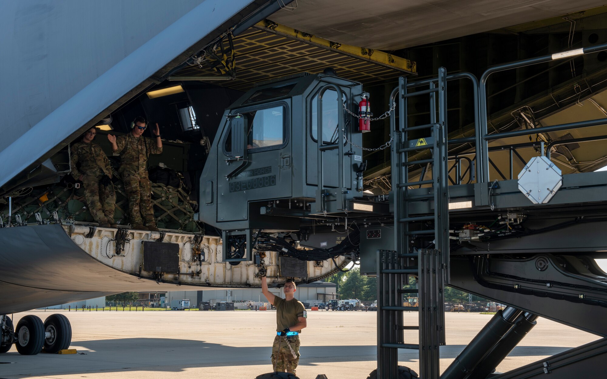 Members from the 9th Airlift Squadron and 436th Aerial Port Squadron guide a K-loader toward the ramp of a C-5M Super Galaxy during the Liberty Eagle Readiness Exercise at Dover Air Force Base, Delaware, July 11, 2022. Members from both the 512th and 436th airlift wings participated in a simulated deployment to a forward operating base, located on Dover AFB, July 11-15, 2022. The purpose of this exercise was to validate the 512th and 436th airlift wings' ability to generate, employ and sustain airpower across the world in a contested and degraded operational environment. (U.S. Air Force photo by Senior Airman Shayna Hodge)