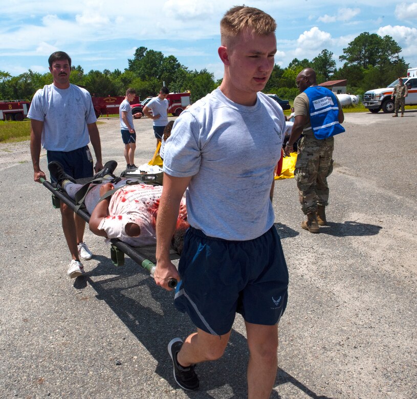 Senior Airman Nicholas Athan, 633d Surgical Operations Squadron surgical technologist, and  Airman 1st Class  Brandon Powell, 633d Surgical Operations Squadron medical technician, carries a moulage patient to the proper triage location during the 633rd Medical Group’s Comprehensive Medical Readiness Training exercise at Joint Base Langley-Eustis, Virginia, July 28, 2022.