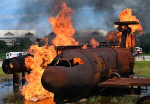 A mock aircraft used for simulated fire trainings is set ablaze as part of the Comprehensive Medical Readiness Training exercise at Joint Base Langley-Eustis, Virginia, July 28, 2022.