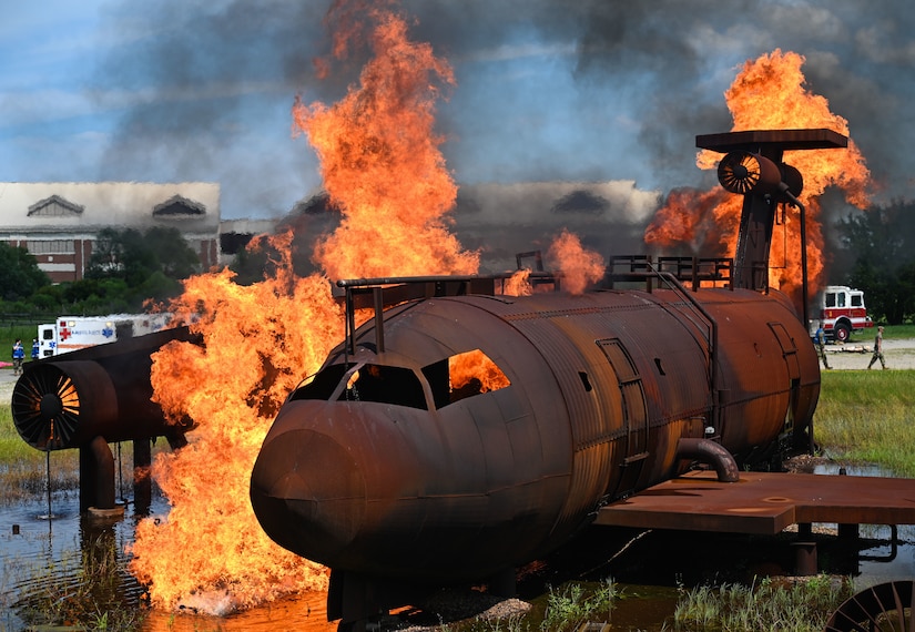 A mock aircraft used for simulated fire trainings is set ablaze as part of the Comprehensive Medical Readiness Training exercise at Joint Base Langley-Eustis, Virginia, July 28, 2022.