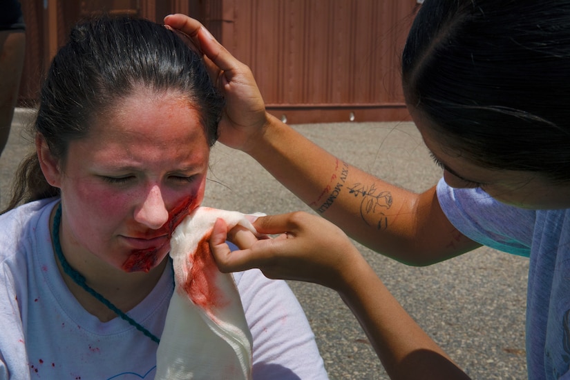 A U.S. Air Force medical technician from the 633rd Medical Group wipes the blood of a moulage patient during a training exercise at Joint Base Langley-Eustis, Virginia, July 28, 2022.