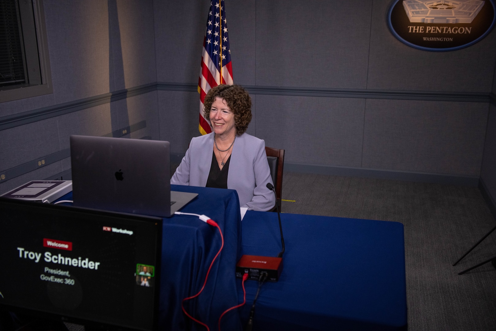 A seated woman looks at a computer monitor.