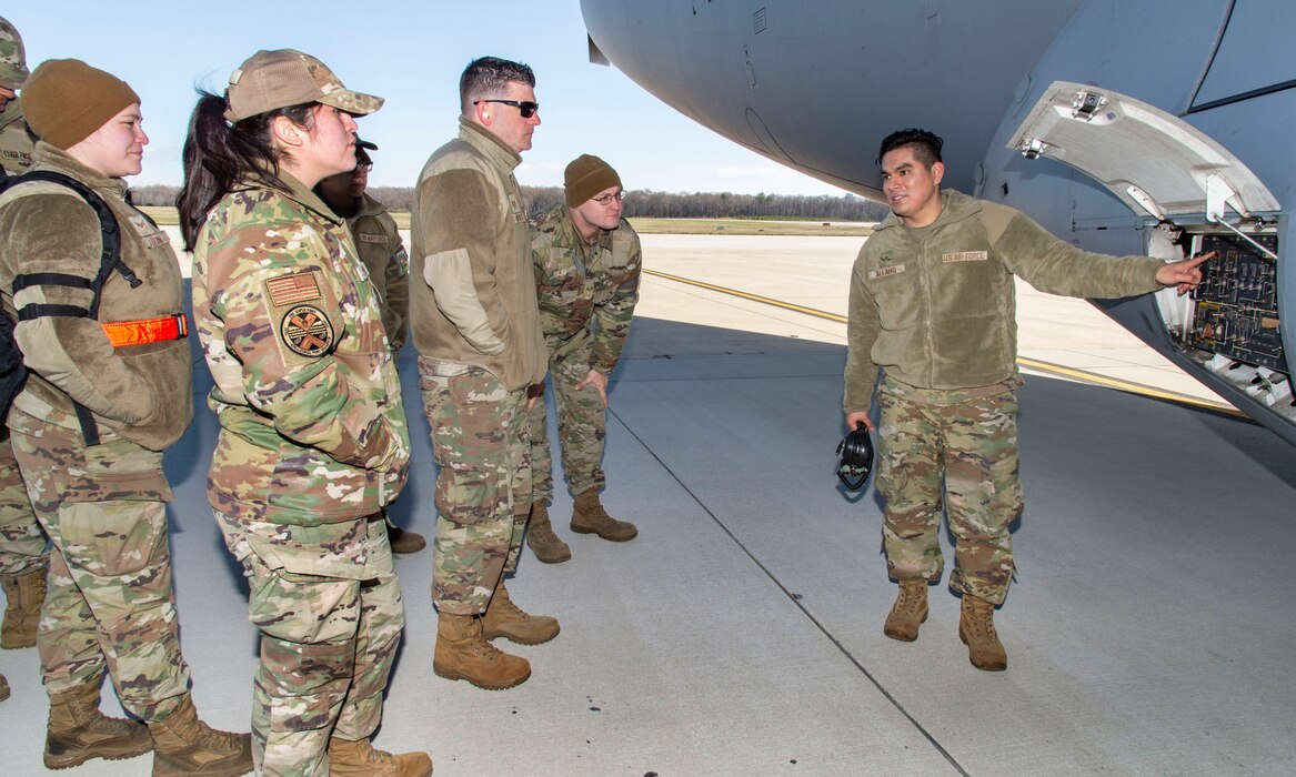 Staff Sgt. Renato Alfaro, right, 373rd Training Squadron, Detachment 3 C-17 aircraft general instructor, familiarizes students with the C-17 Globemaster III refuel panel at Dover Air Force Base, Delaware, March 29, 2022. Alfaro provided students participating in a multi-capable Airmen training class with basic C-17 aircraft familiarization. (U.S. Air Force photo by Roland Balik)