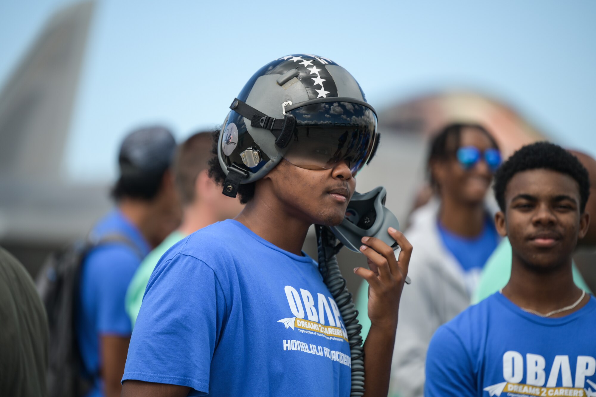 A student with the Organization of Black Aerospace Professionals Aerospace Career Education Academy wears a 19th Fighter Squadron F-22 Raptor helmet during a tour at Joint Base Pearl Harbor-Hickam, Hawaii, July 28, 2022. Lt. Col. Paul Lopez, 19th FS commander, briefed on the squadron’s history, aircraft and mission in the Indo-Pacific during the tour. (U.S. Air Force photo by Staff Sgt. Alan Ricker)
