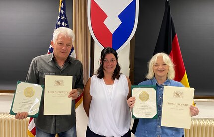 The director of Base Support Operations Maintenance, Stephanie Kramer, presents 40-year length of service certificates to Sabine Diener and Herbert Albersdorfer at the BASOPS Maintenance headquarters in Grafenwoehr, Aug. 10. Diener and Albersdorfer also received certificates of recognition from the State of Bavaria for their 40 years of employment with the U.S. Army.