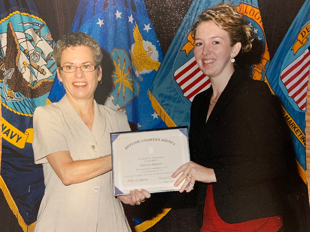 Two ladies stand with a certificate for photo
