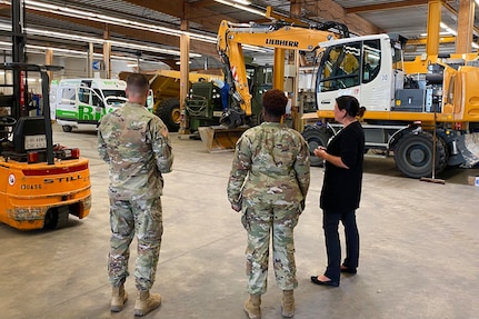 Stephanie Kramer, the director of Base Support Operations Maintenance, shows the 405th Army Field Support Brigade command team, Col. Crystal Hills and Command Sgt. Maj. Terrell Brisentine, the inside operations of one of BASOPS Maintenance’s equipment maintenance and repair facilities, Aug. 9, in Grafenwoehr, Germany.