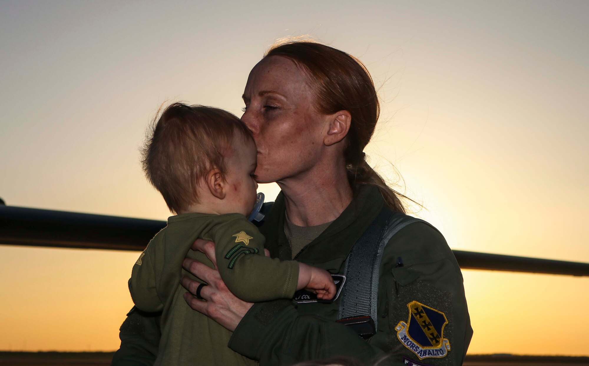 Following a Norway bomber task force deployment, a pilot kisses her baby upon return home.