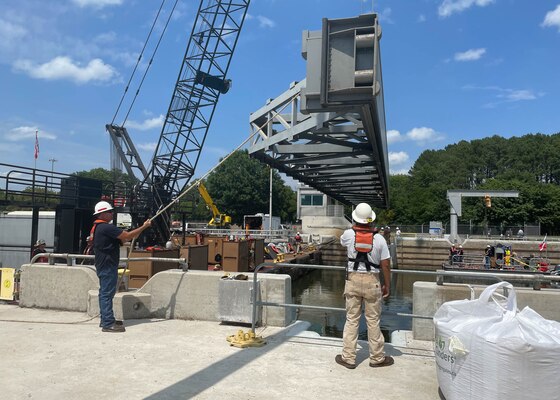 Nashville District engineers, with the help of Huntington District engineers, use a crane to lower the 63,000-pound stop log into the water so divers can check the placement and ensure j-seals are working properly at Cheatham Lock in Ashland City, TN.