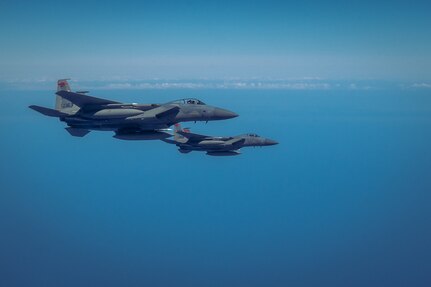 A pair of F-15 Eagle fighter jets assigned to Barnes Air National Guard Base, fly alongside a KC-46 Pegasus assigned to the 157th Air Refueling Wing, in the sky off the coast of New England. The fighters were refueled by the KC-46 as part of the Super Sortie exercise, Aug. 3, 2022.