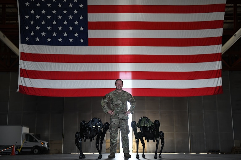 U.S. Air Force Tech Sgt. Brandon Priddy, 45th Security Forces Squadron non-commissioned officer in charge of innovation and technology poses for a picture with Ghost Robotics Vision 60 Quadruped Unmanned Ground Vehicles (Q-UGV) at Cape Canaveral Space Force Station, Fla., July 28, 2022. The Q-UGV will be used for damage assessments and patrol to save significant man hours. (U.S. Space Force photo by Senior Airman Samuel Becker)