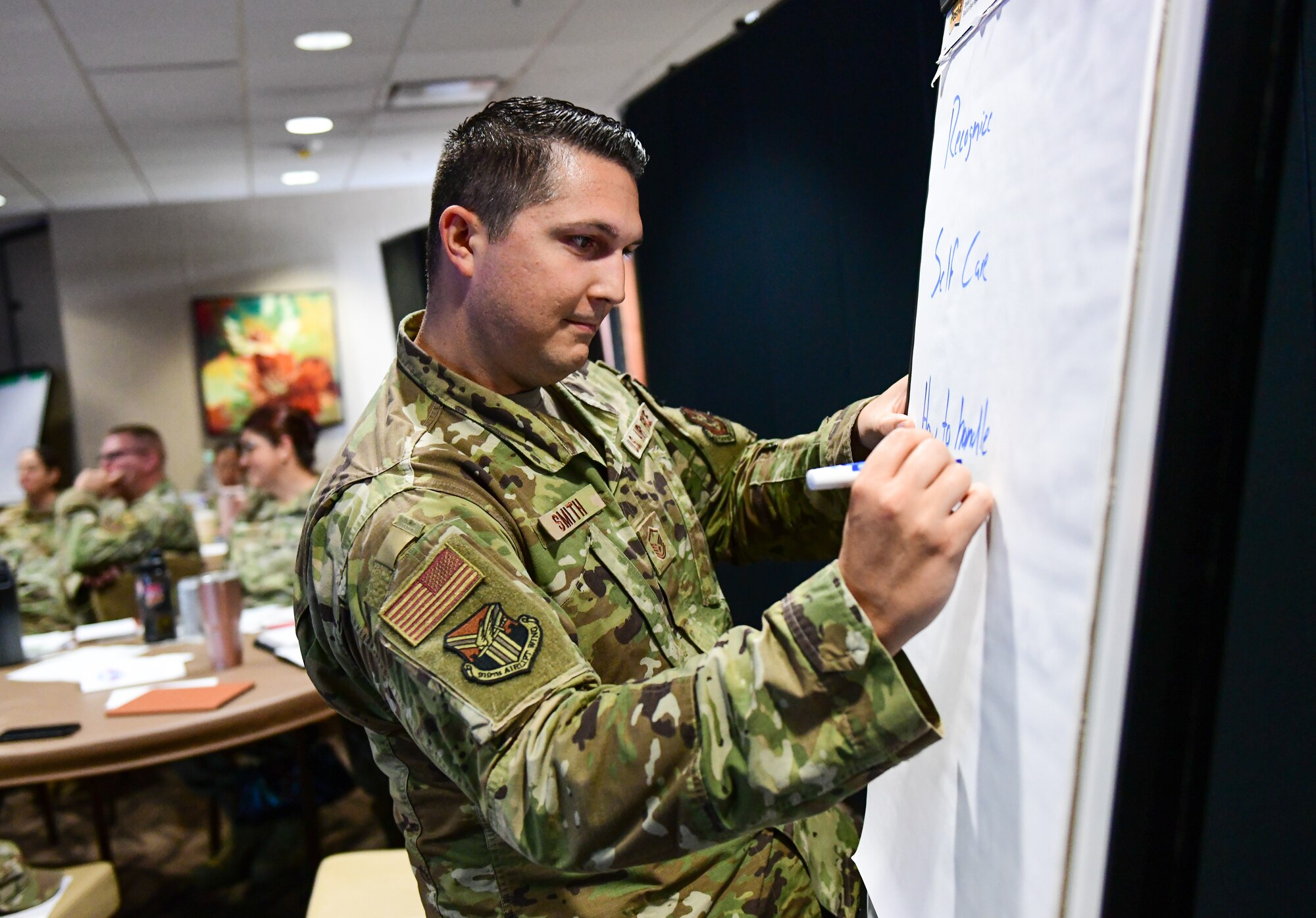 Master Sgt. Joshua Smith, non-commissioned officer-in-charge of the emergency medical technical flight, writes down ideas on a board during a senior non-commissioned officer enlisted symposium, Aug. 9, 2022, at Youngstown Air Reserve Station, Ohio.