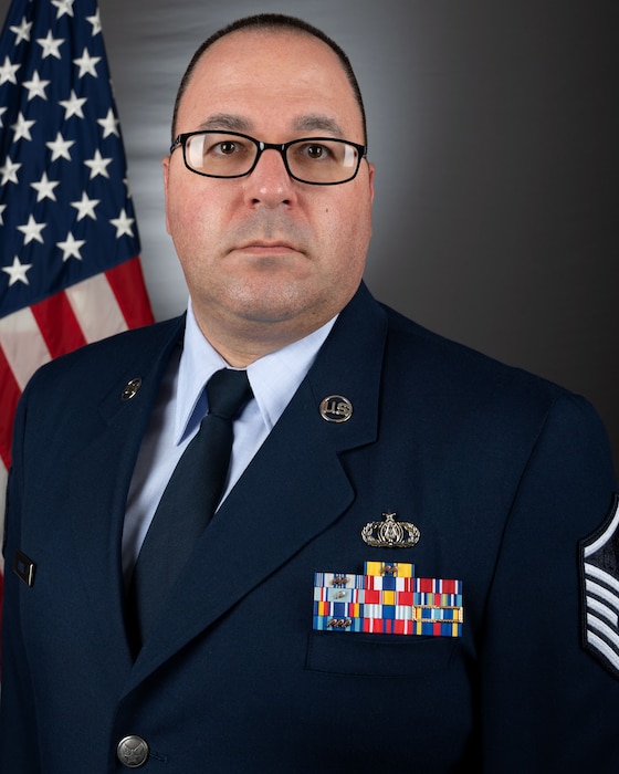 An official bio photo of MSgt David Fatek in front of the American flag. He is wearing the blue service dress uniform.