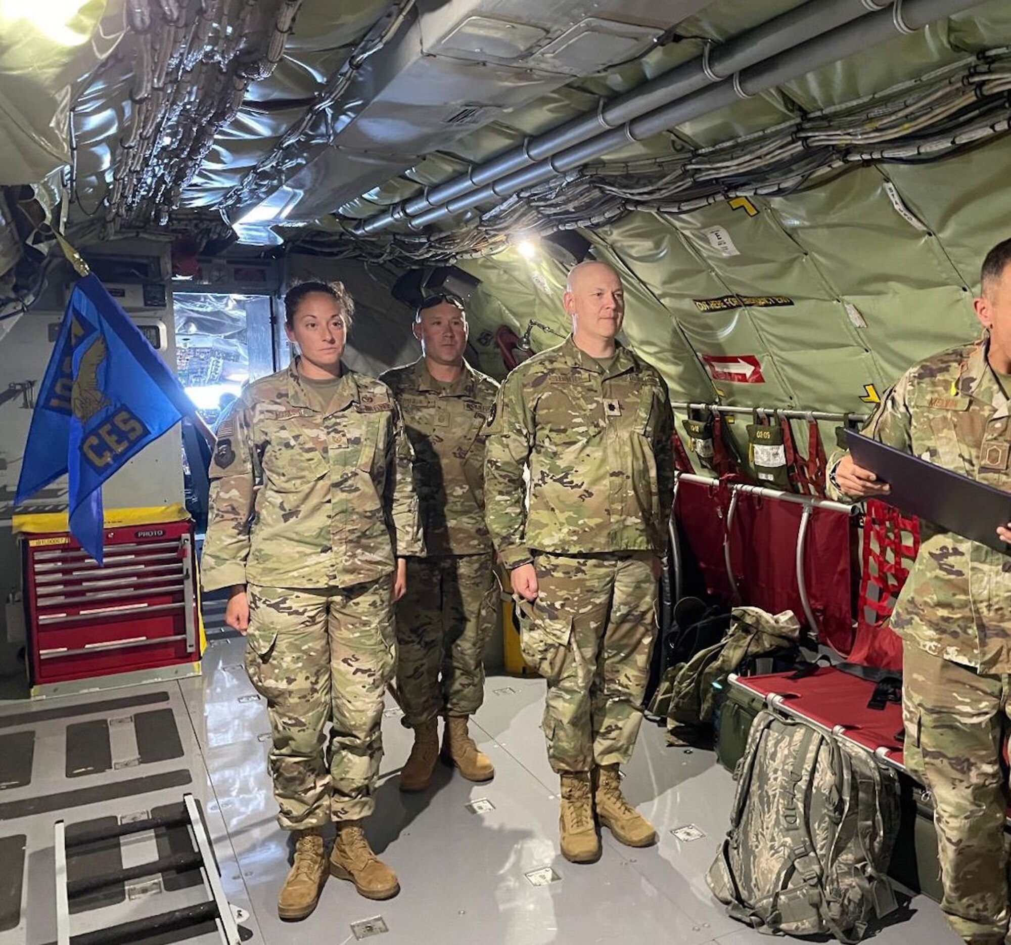 An officer promoting an Airman to the senior non-commissioned grade of Master Sgt. while in flight on board a KC-135 refueling aircraft.