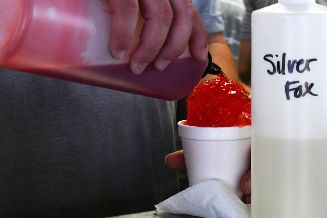 David Howell, 97th Maintenance Squadron director, prepares a sno-cone at the “Back to School-A-Palooza” at Altus Air Force Base, Oklahoma, Aug. 5, 2022. Attendees received snacks and sno-cones during the event. (U.S. Air Force photo by Airman 1st Class Miyah Gray)