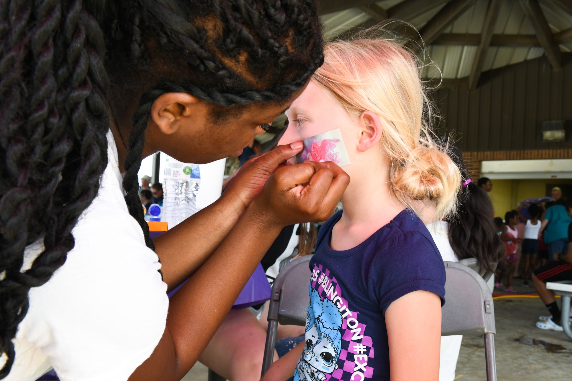 U.S. Air Force Airman Shanice Tindall, 97th Logistics Readiness Squadron aerial operations apprentice, paints a child’s face at the “Back to School-A-Palooza” at Altus Air Force Base, Oklahoma, Aug. 5, 2022. The event featured many immersive activities for children to enjoy including a bounce house, dunk tank and a foam machine. (U.S. Air Force photo by Airman 1st Class Miyah Gray)