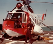 AM2 Dave Moynihan, USCG, stands beside  his creation -- the HH-52 "Love Ma'chine" he "converted" aboard USCGC Alert off Nassau, Bahamas, March, 1981.