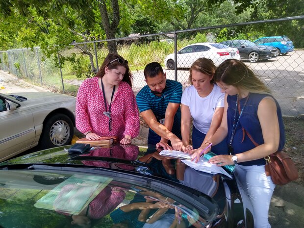 Kelsey Ciarrocca (second from right), a cartographer with the U.S. Army Corps of Engineers (USACE) Galveston District, points out properties on a map before conducting rights-of-entry (ROE) visits in a south Texas neighborhood. 


Ciarrocca’s work involves supporting project delivery teams—made up of USACE staff and contractors—who do most of their work out in the field. This includes a lot of going door-to-door securing critical ROEs from private landowners to access properties. Without the ROEs, the Real Estate Division can’t conduct important surveys and geotechnical investigations.