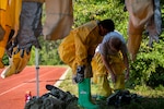 Medical Airmen put on their protective gear during a decontamination exercise June 23 at Eglin Air Force Base, Fla.  The chemical/biological exercise was part of required deployment training for Airmen medics.  More than 60 completed the three-day training course.  (U.S. Air Force photo/Samuel King Jr.)