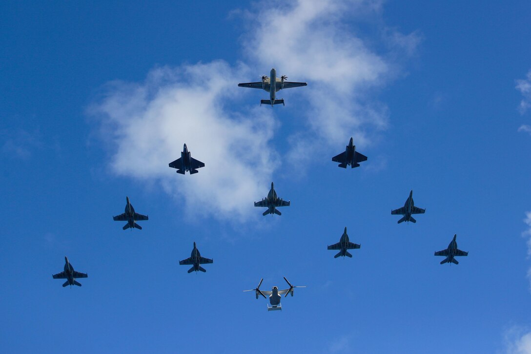 Aircraft, viewed from below, fly in a triangular formation.