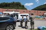 Sgt. Austin Morrison, Spc. Donnie Brinson, and Spc. Christopher Stockdale with the 1163rd Medical Co., 75th Troop Command, helped load water, food and other supplies for flood victims in Whitesburg, Ky. The Soldiers were part of a point of a distribution site at Letcher County Central High School.