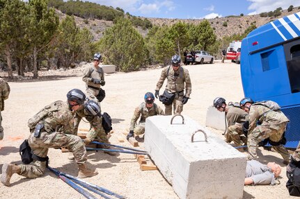 Rescue workers lift a slab of concrete off a dummy simulating a casualty