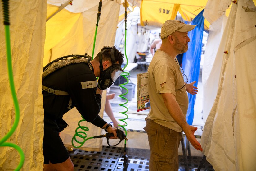 A rescue worker decontaminates a civilian during an exercise